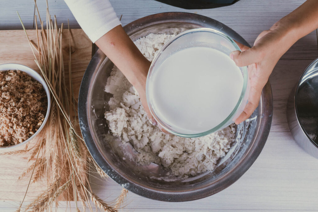 Kaip pasigaminti mieles: vanduo pilamas į dubenį su miltais šalia grūdų ir prieskonių.