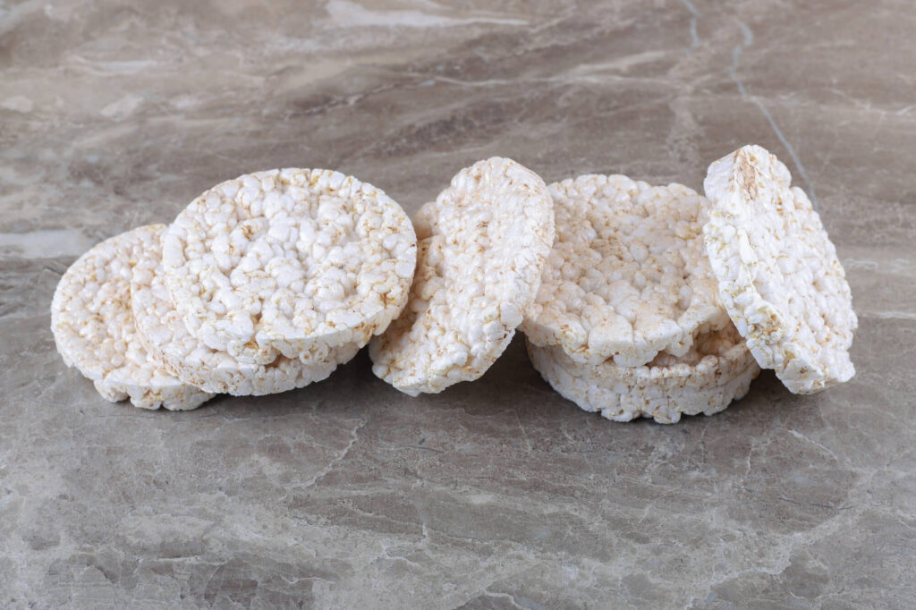 Produktai mažinantys skrandžio rūgštingumą – ryžių trapučiai ant akmens paviršiaus.