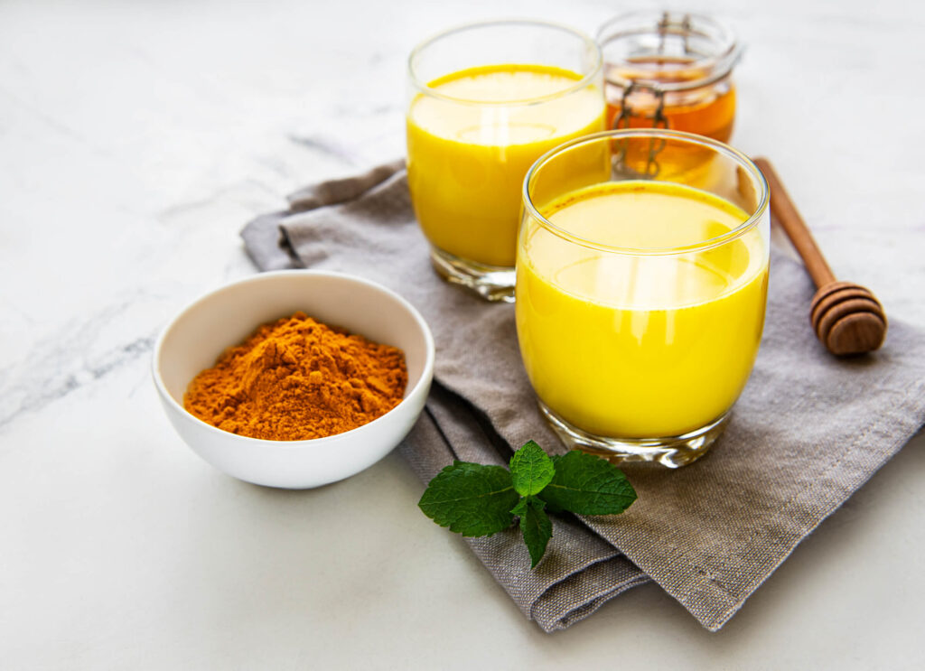 Auksinis pienas su ciberžolės milteliais ir medumi stiklinėse