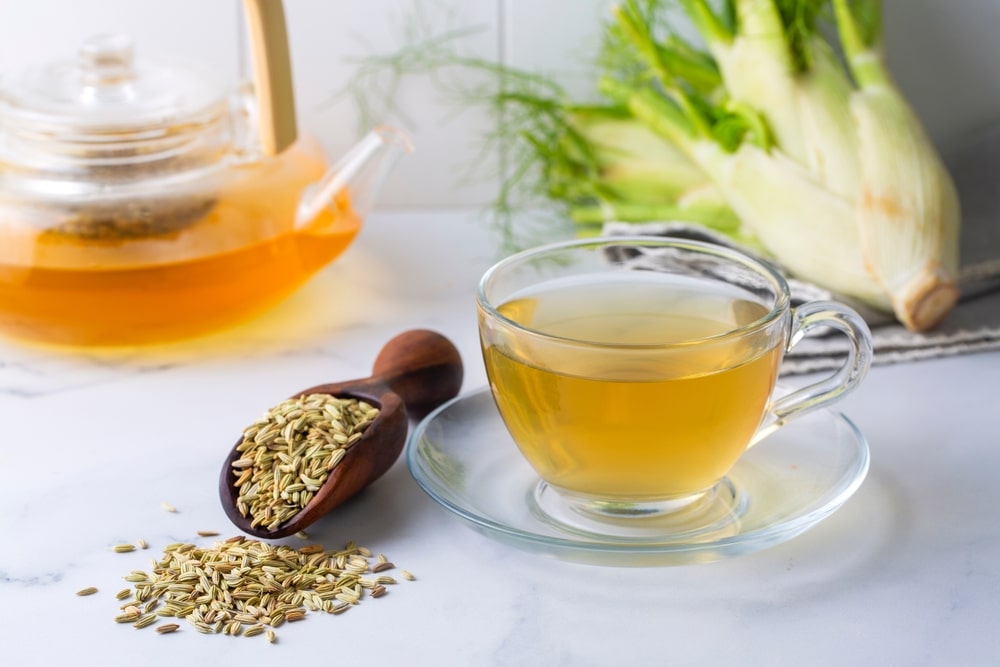 3 arbatos lieknėjimui – švelnios pankolių arbatos puodelis šalia sėklų ir šviežio pankolio