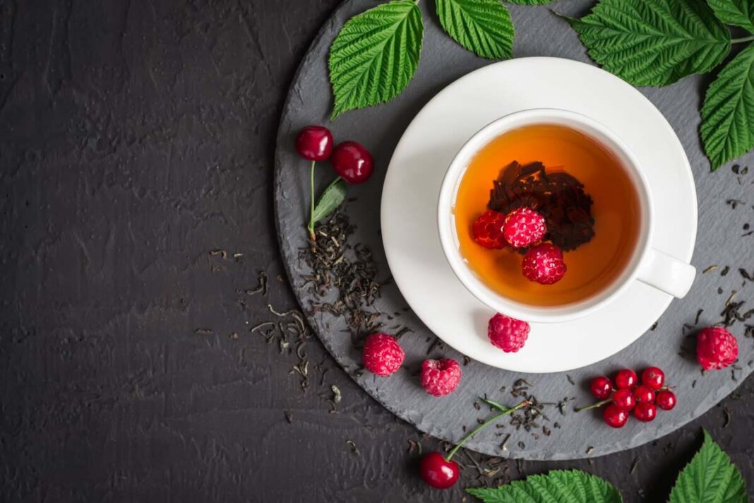 Aviečių arbata – puodelis su uogomis ir lapais, natūralus gėrimas imunitetui stiprinti