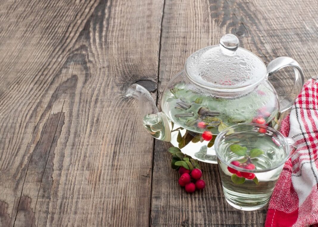 Bruknių lapų arbata stiklinėje ir stikliniame arbatinyje – natūrali, švelni priemonė organizmo stiprinimui.