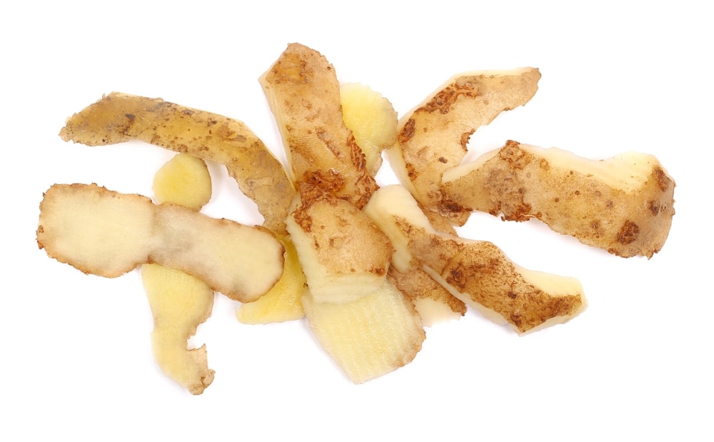 Šviežios bulvių lupenos baltame fone – tinka naudoti kaip natūralią trąšą įvairiems augalams.