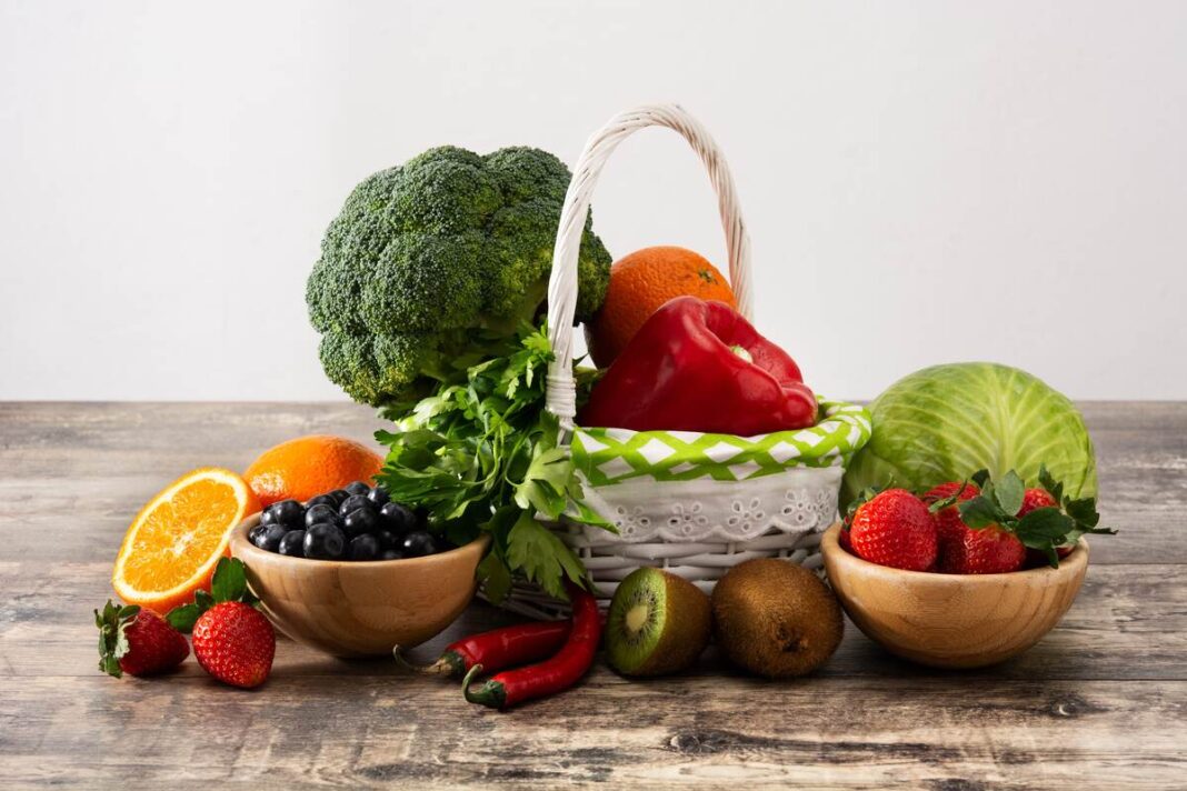 Daugiausiai vitamino C turinčios daržovės ir vaisiai – šviežių gėrybių krepšelis su paprika, brokoliais, kopūstu ir kitomis naudingomis daržovėmis.