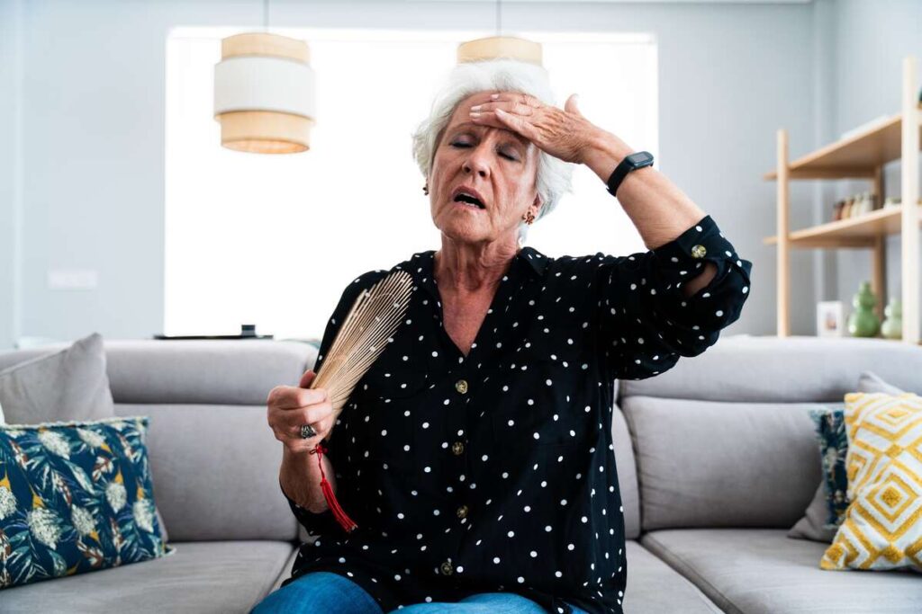 Produktai nuo tinimo – moteris karštą dieną jaučia diskomfortą dėl patinimų, susijusių su netinkama mityba.