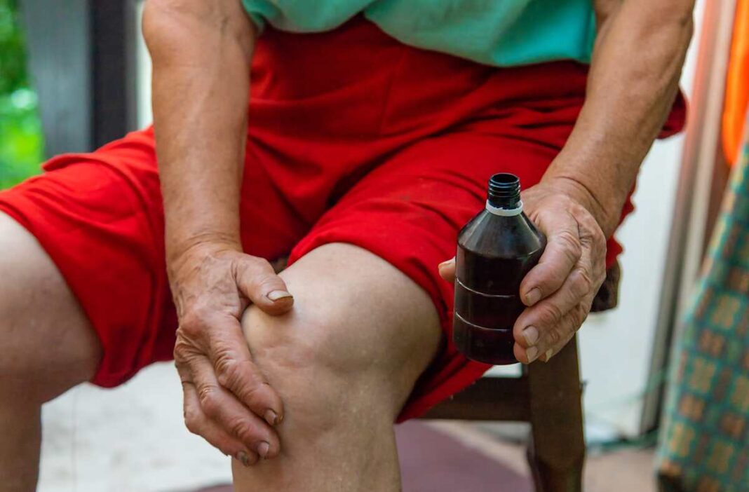 Raminantis aliejus sąnariams tepamas ant skaudančio kelio – natūrali pagalba nuo artrito ir uždegimo.