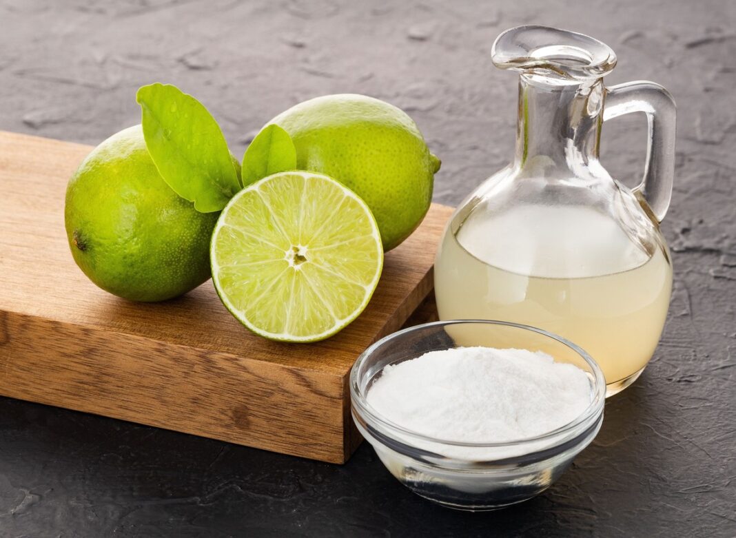 Riebalus tirpdantis gėrimas su citrinų sultimis ir soda – natūralūs ingredientai ant medinės lentos.