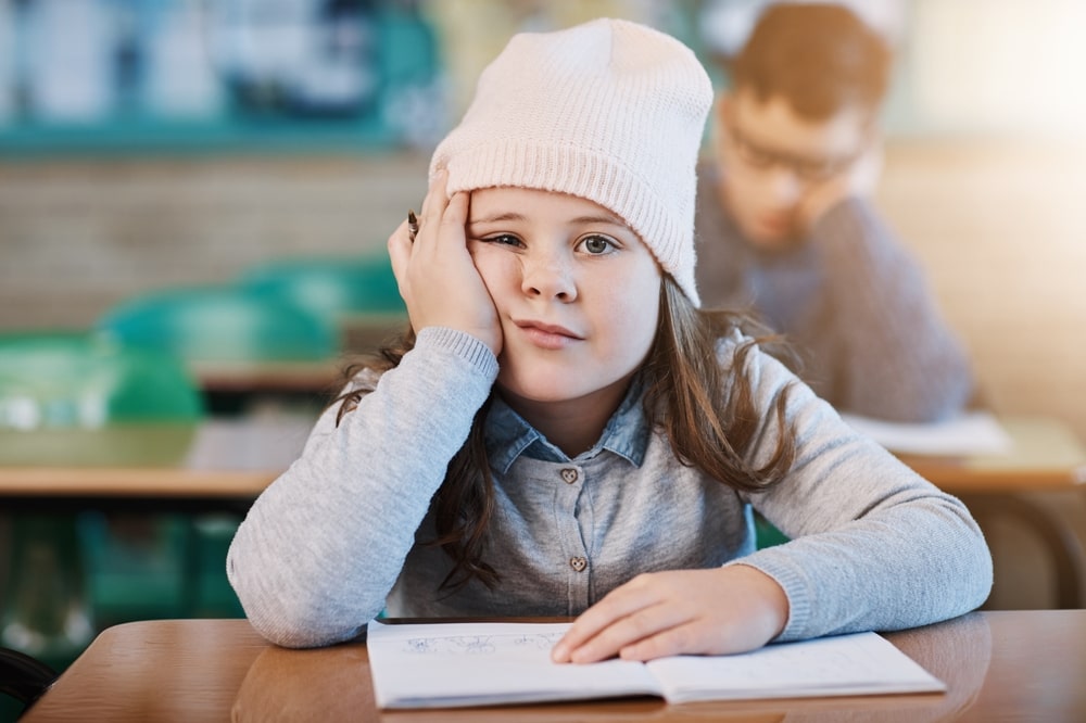 ADHD diagnozė akyse – mokykloje besimokantis vaikas, rodantis dėmesio sutrikimo požymius.