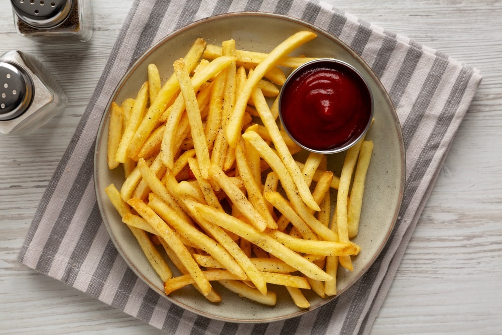 Lėkštėje patiektos bulvytės fri su kečupu – užkandis, kuris, pasak mokslininkų, gali padidinti diabeto riziką.