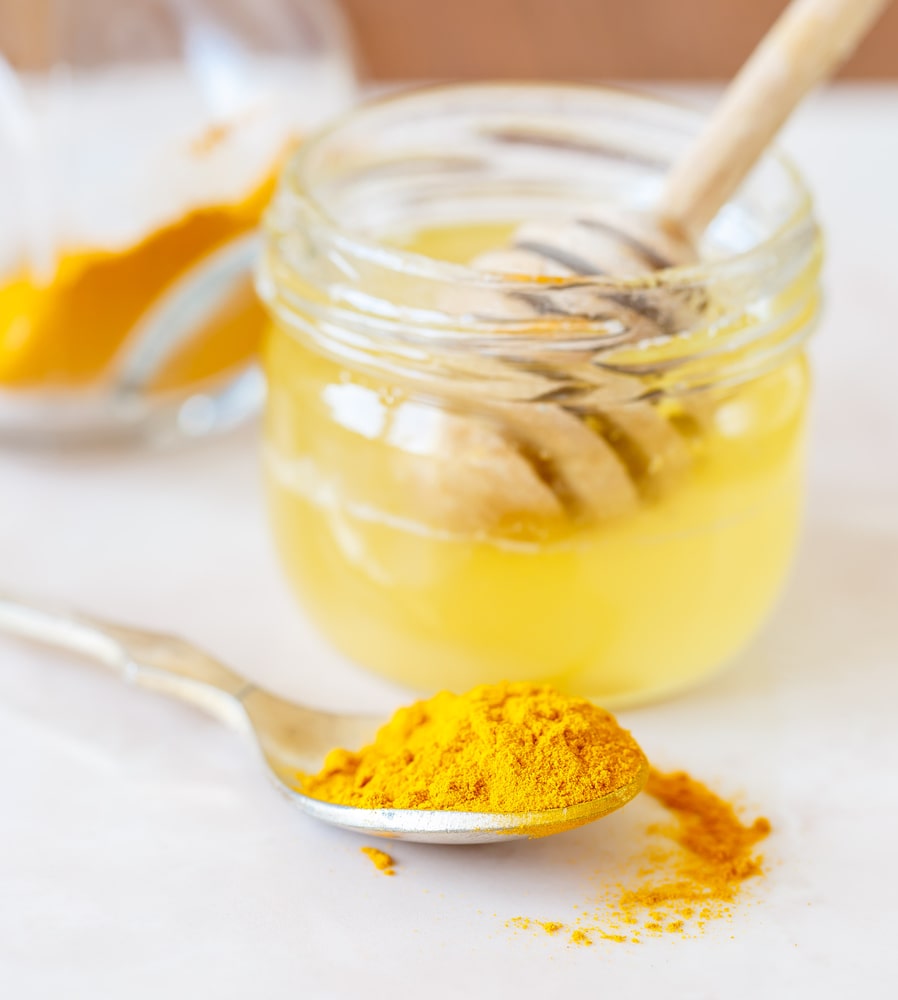 Šaukštelis ciberžolės ir medaus stiklainis – pagrindiniai mišinio su česnaku ingredientai