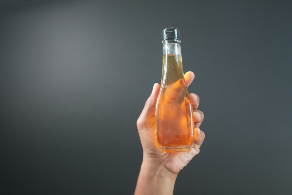 Kombucha nauda sveikatai – butelis fermentuotos arbatos laikomas rankoje, puikiai tinkantis gaivai ir organizmo stiprinimui.