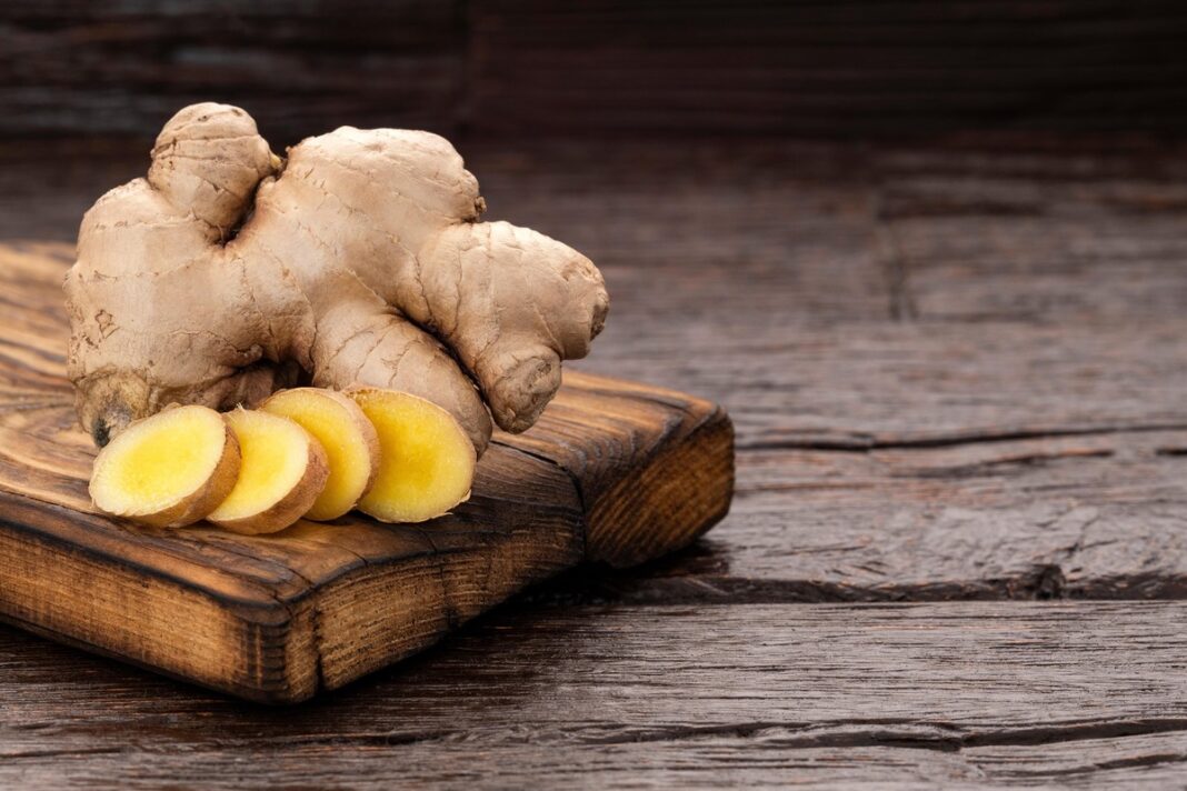 Šviežias imbieras ant medinės lentelės – natūralus priešuždegiminis vaistas, padedantis stiprinti organizmą.