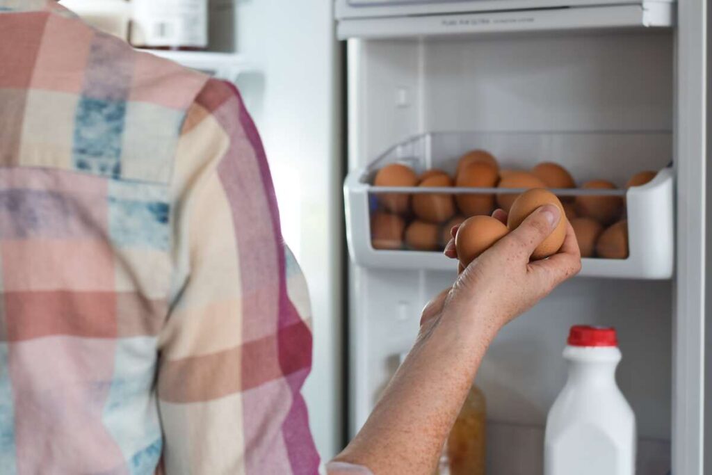 Rankoje laikomi kiaušiniai prieš padedant juos į šaldytuvą – saugus virtų kiaušinių laikymas.