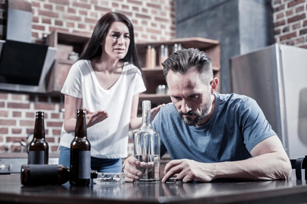 Moteris bando kalbėtis su vyru dėl jo priklausomybės alkoholiui – įtempta situacija šeimoje.