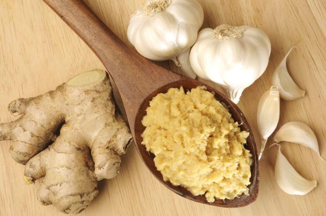 gamtos antibiotikai česnakas su imbieru ir pasta mediniame šaukšte – natūrali priemonė imunitetui.
