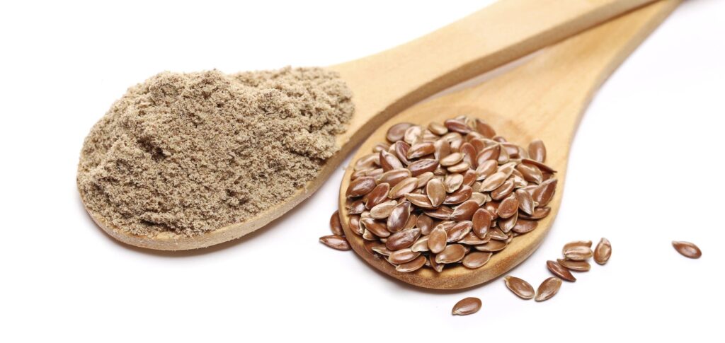 malti linų sėmenys žarnynui – šaukštai su rudomis sėklomis ir sumalta jų forma.