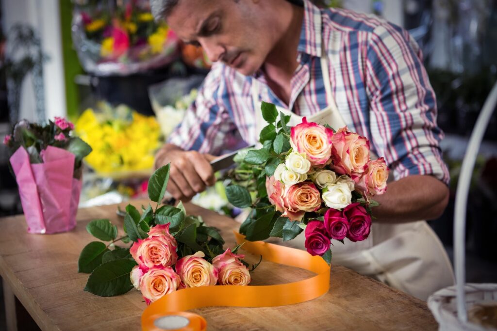 rožės sodinimas iš puokštės – floristas paruošia rožių stiebus, kad juos būtų galima įsišaknyti ir persodinti