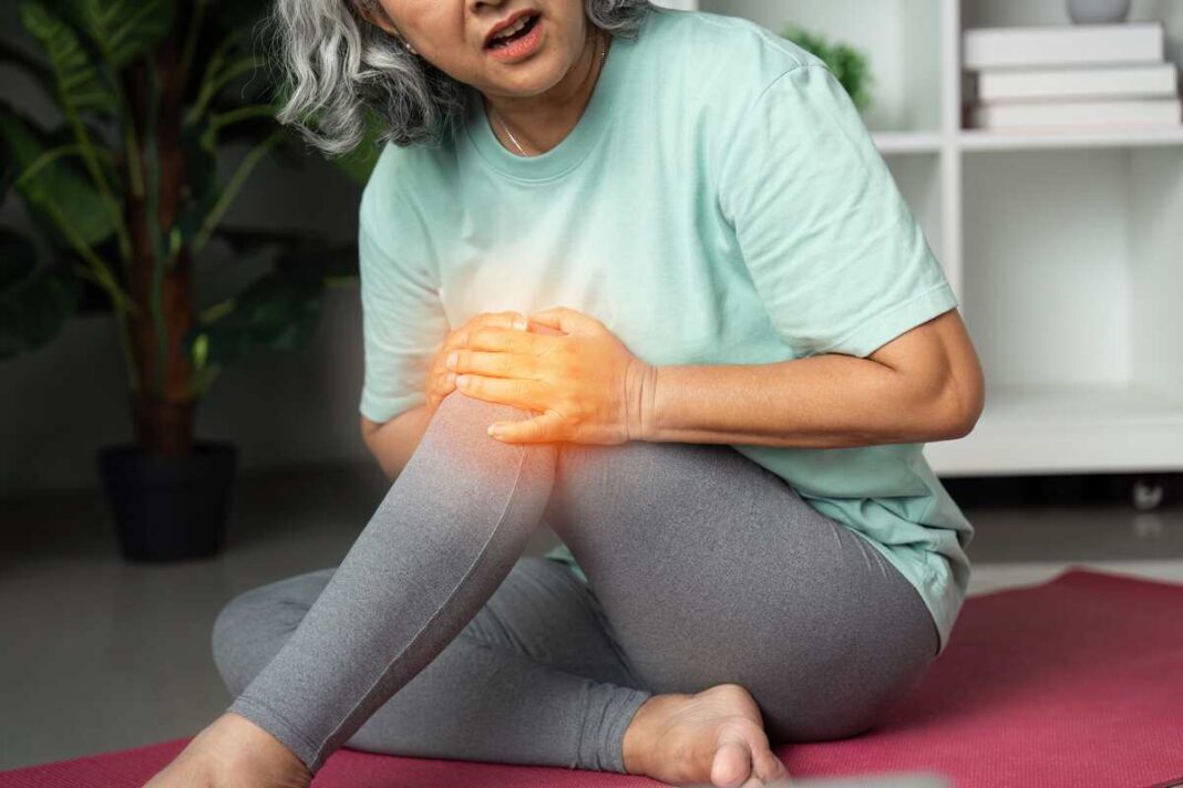 Sąnarių lankstumo palaikymas – moteris jaučia kelio skausmą mankštos metu, iliustruojantis sąstingio poveikį.