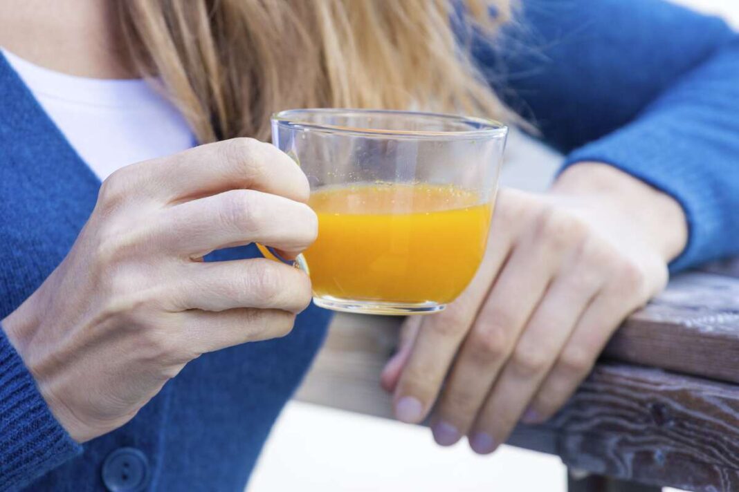 2 savaičių arbatos kursas – žmogus rankoje laiko puodelį šiltos geltonos arbatos.