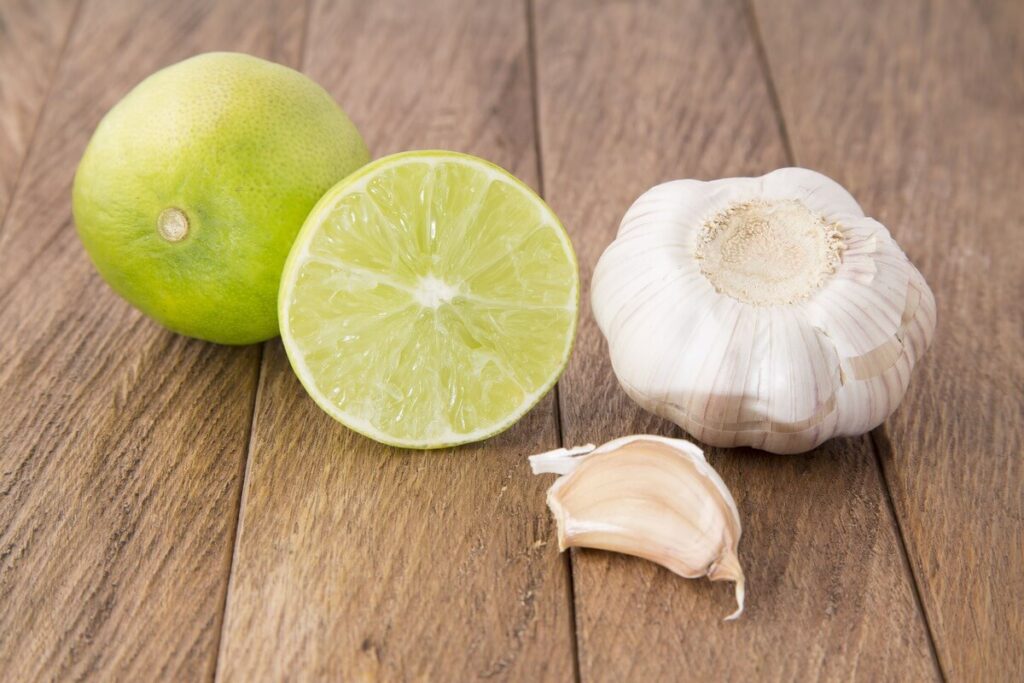 česnakas nuo kosulio susmulkintos skiltelės su medumi ir citrina ant pjaustymo lentelės