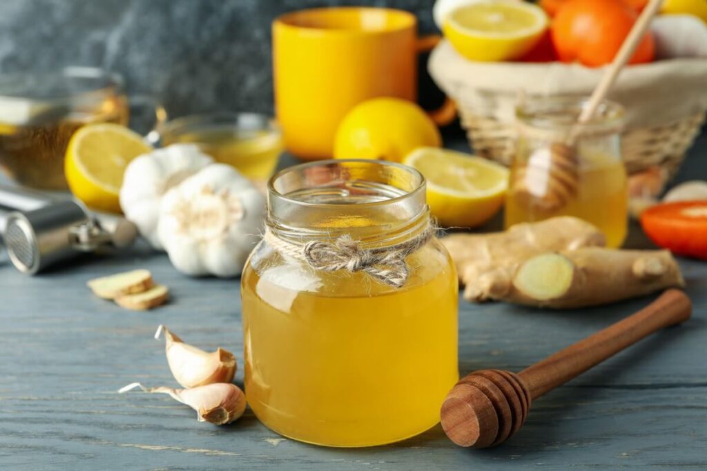 cesnako-medaus-misinys stiklainiuose su česnako gabalėliais ir medumi.