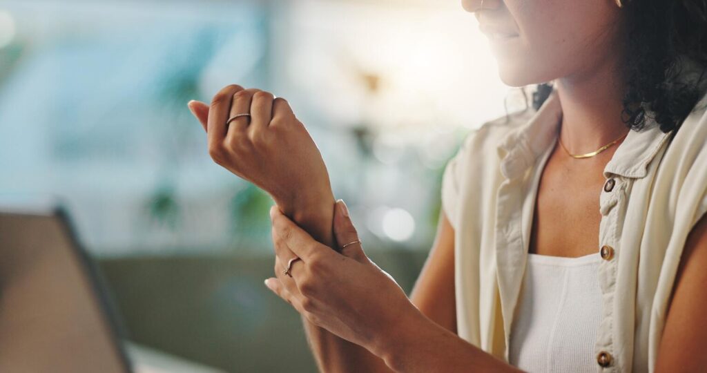 česnako mišinys sąnariams – moteris laiko ranką dėl riešo skausmo, natūralios pagalbos ieškojimas.