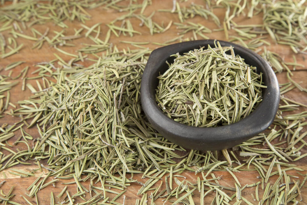 dziovintas-rozmarinas juodame indelyje ir issklaidytas ant lentos