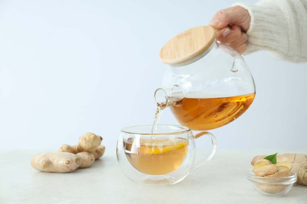 gerimas kūno detoksikacijai pilamas iš stiklinio arbatinuko į puodelį su imbiero griežinėliais