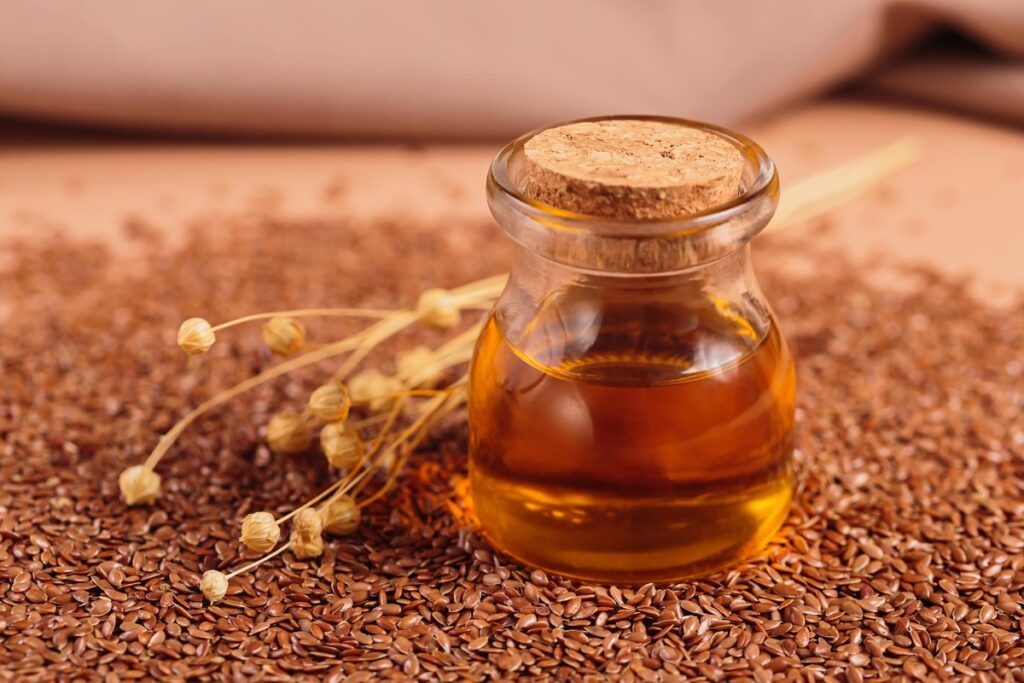 gėrimas pilvo riebalams mažinti su linų sėmenų aliejumi ir sėklomis stikliniame inde