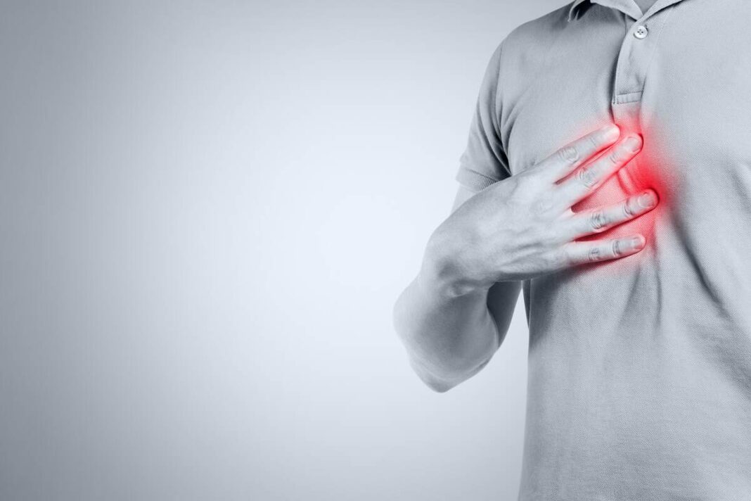 kas sukelia rėmenį vyras laiko ranką ant krūtinės, juntamas deginimo pojūtis dėl rūgšties refliukso.