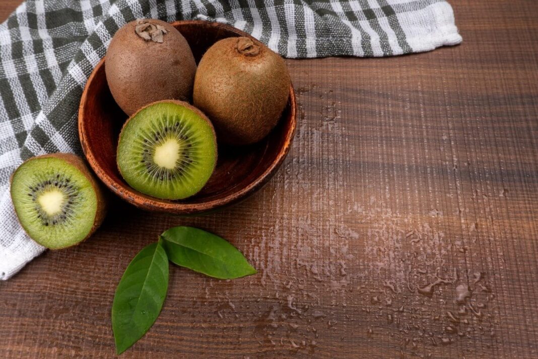 kivių nauda organizmui švieži kiviai perpjauti ant medinio stalo