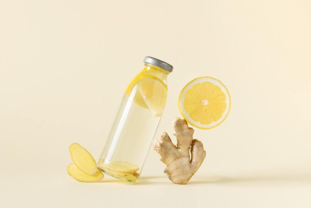 Kraujo skystinimas be vaistų – stiklinis butelis su imbieru ir citrina natūraliam kraujotakos stiprinimui.