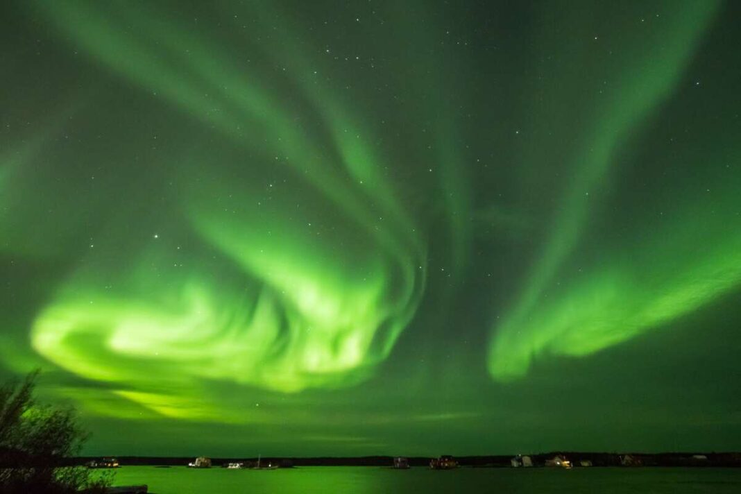 magnetinės audros poveikis žmogui – danguje šokančios žalios pašvaistės kaip Saulės aktyvumo ženklas.
