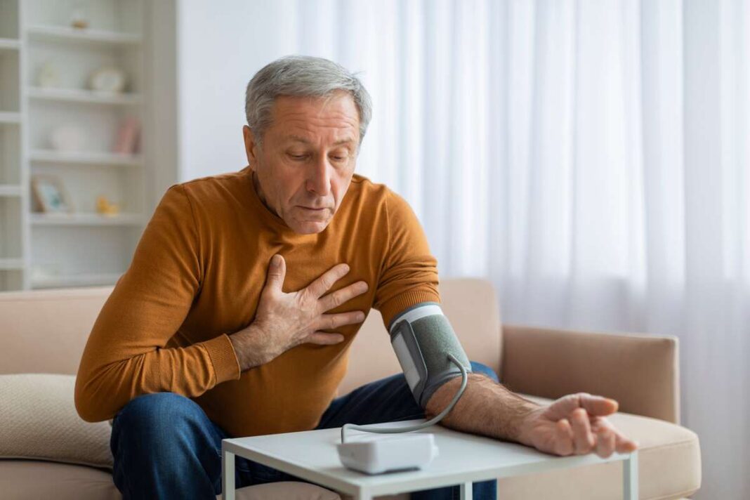 Mišinys nuo aukšto kraujospūdžio – vyras matuojasi kraujospūdį ir jaučia diskomfortą krūtinėje.