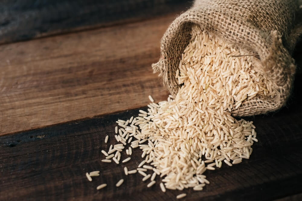 ar ryžiai kenkia sveikatai ryžiai drobiniame maiše ant medinio paviršiaus