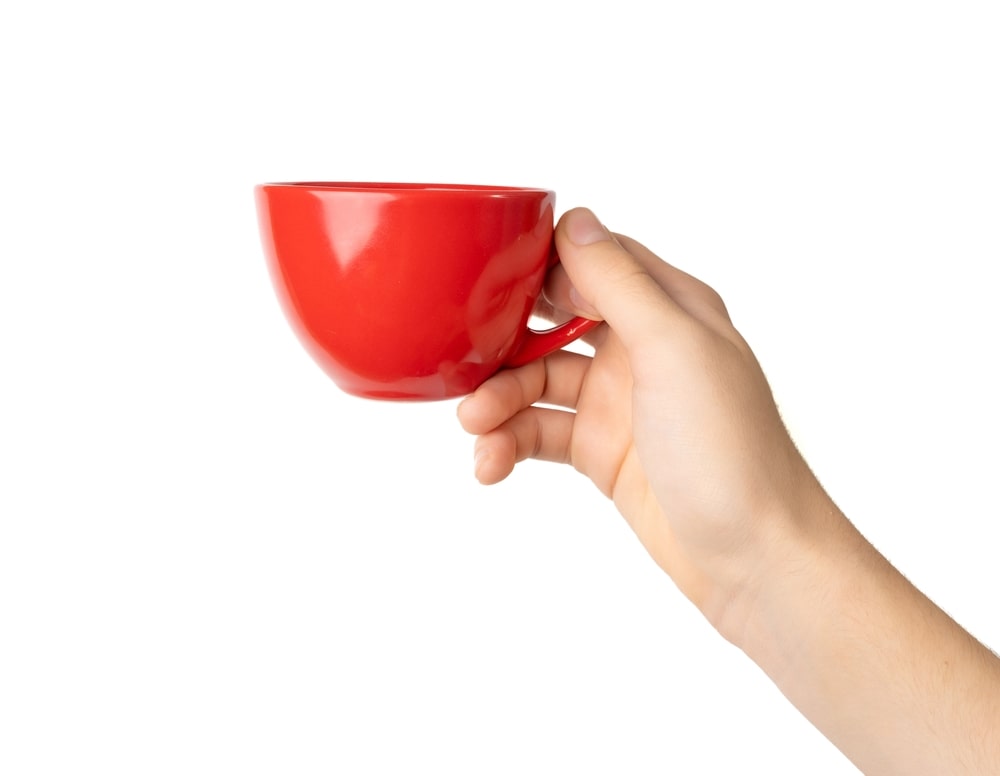 arbata kraujospudziui normalizuoti raudoname puodelyje laikoma rankoje – paprasta, ryški ir tonizuojanti kasdienė sveikatos ritualo dalis