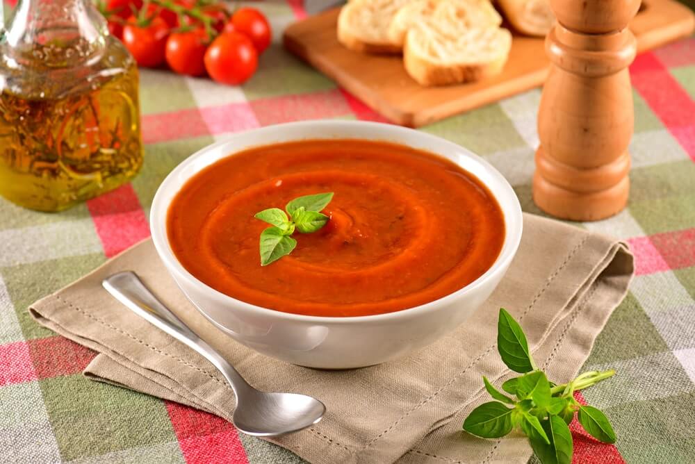 pomidoru sriuba kraujospudziui patiekta dubenelyje su baziliku ant stalo