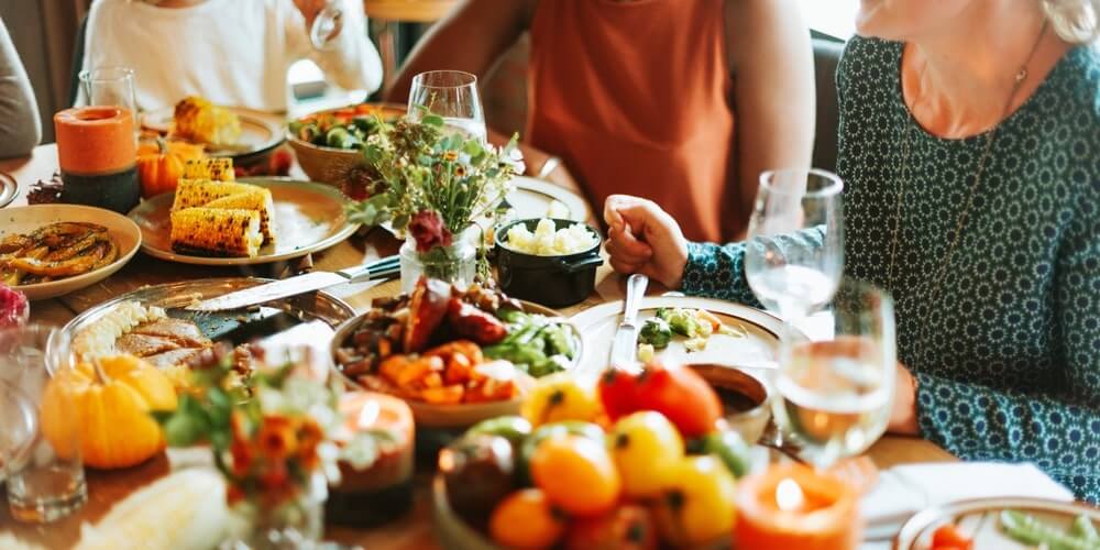 retai valgomas produktas per šventes šalia vaisių ir lengvesnių patiekalų ant stalo