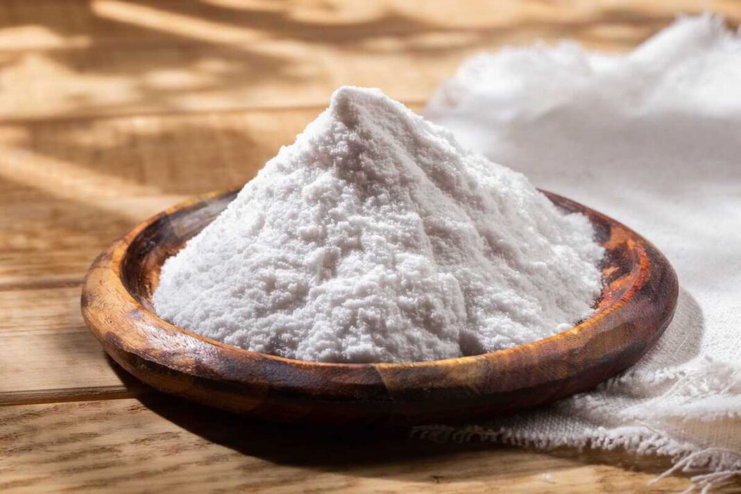 kepimo soda sveikatai suberta į medinį dubenėlį ant natūralaus medinio paviršiaus