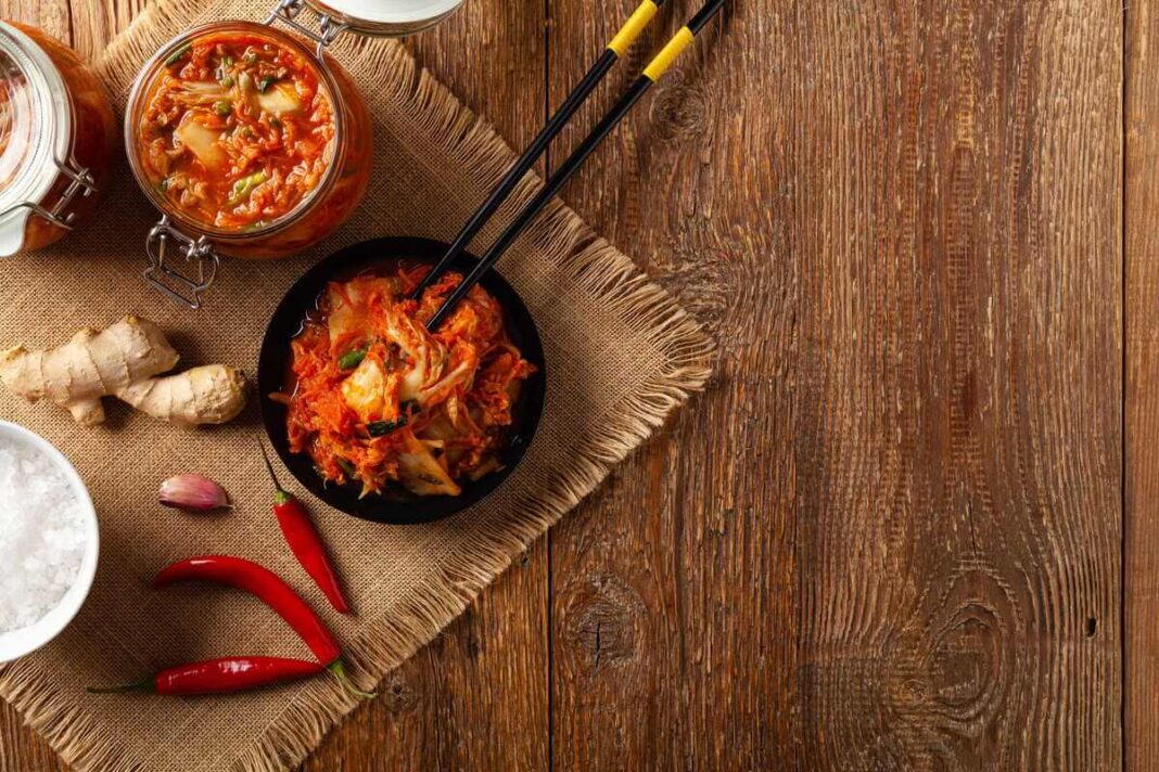 Kimči nauda imunitetui iliustruojama šviežiu užkandžiu juodame dubenėlyje.