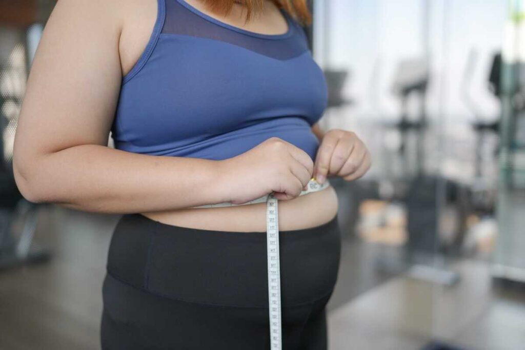 marinuoti agurkai padeda lieknėti žmogus matuoja liemenį sporto salėje