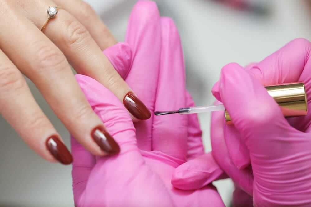 nagų lakavimas atliekamas profesionalaus manikiūro metu