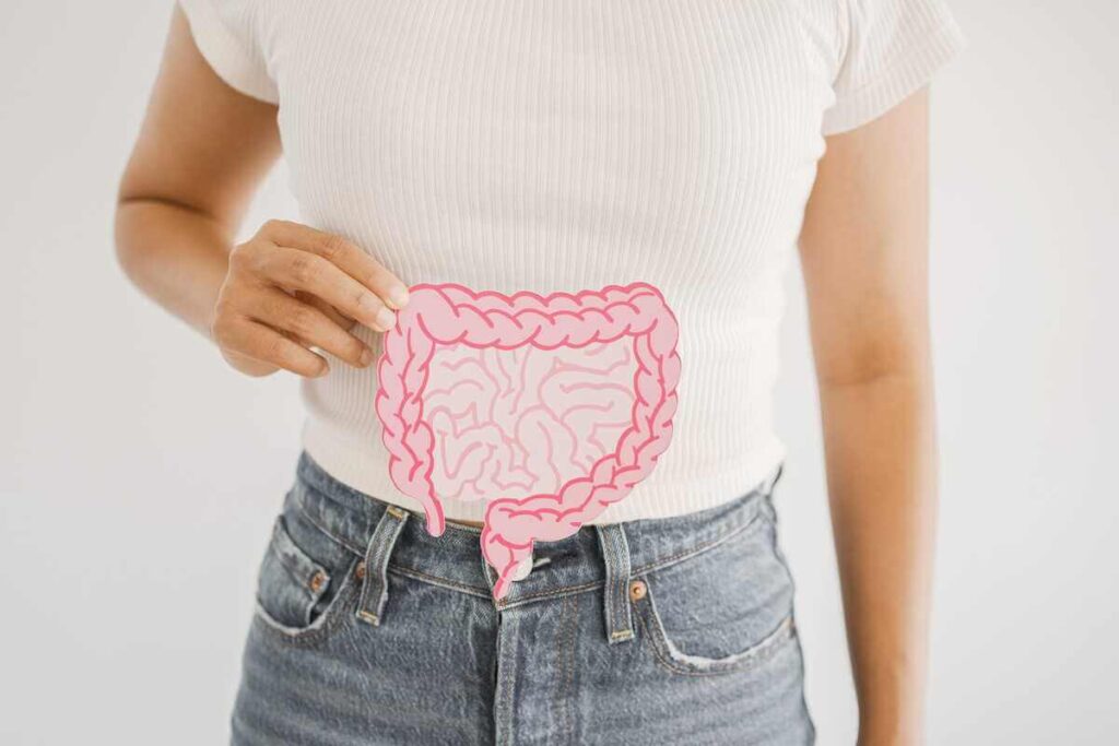 vyšnių sultys žarnynui stiklinėje šalia šviežių rūgščiųjų vyšnių ant šviesaus paviršiaus