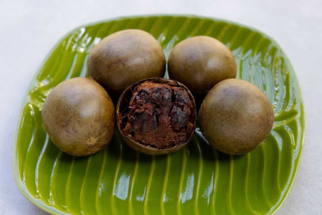 Vienuolių vaisius ant dekoratyvios žalios lėkštės, demonstruojantis savo unikalią išvaizdą ir tekstūrą.