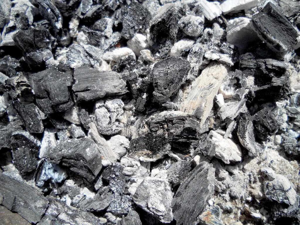 Medžio pelenai pavaizduoti stambiu planu, išryškinant pilką spalvą ir smulkią tekstūrą, tinkamą dirvos kalkinimui.