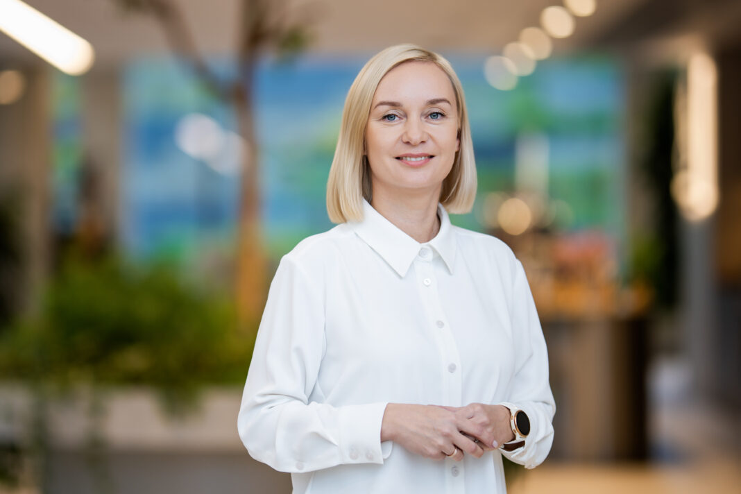 Besijuokianti blondinė balta palaidine moderniame interjere