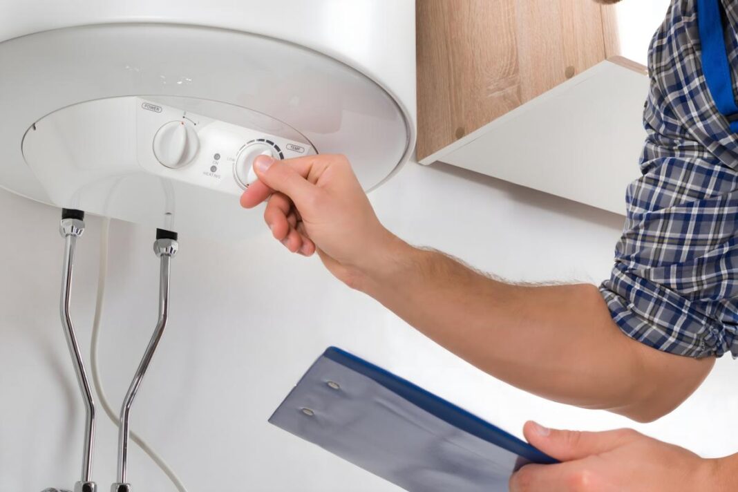 Žmogus reguliuoja elektrinio boilerio temperatūrą