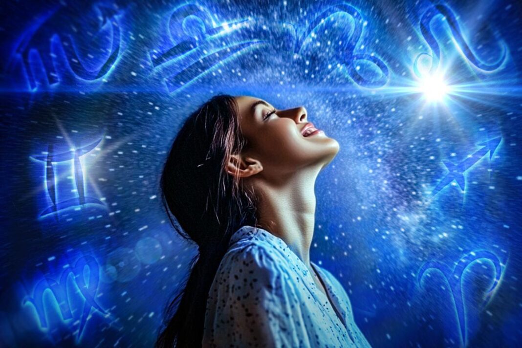 Moteris žvelgia į šviesą mėlyname zodiako ženklų fone