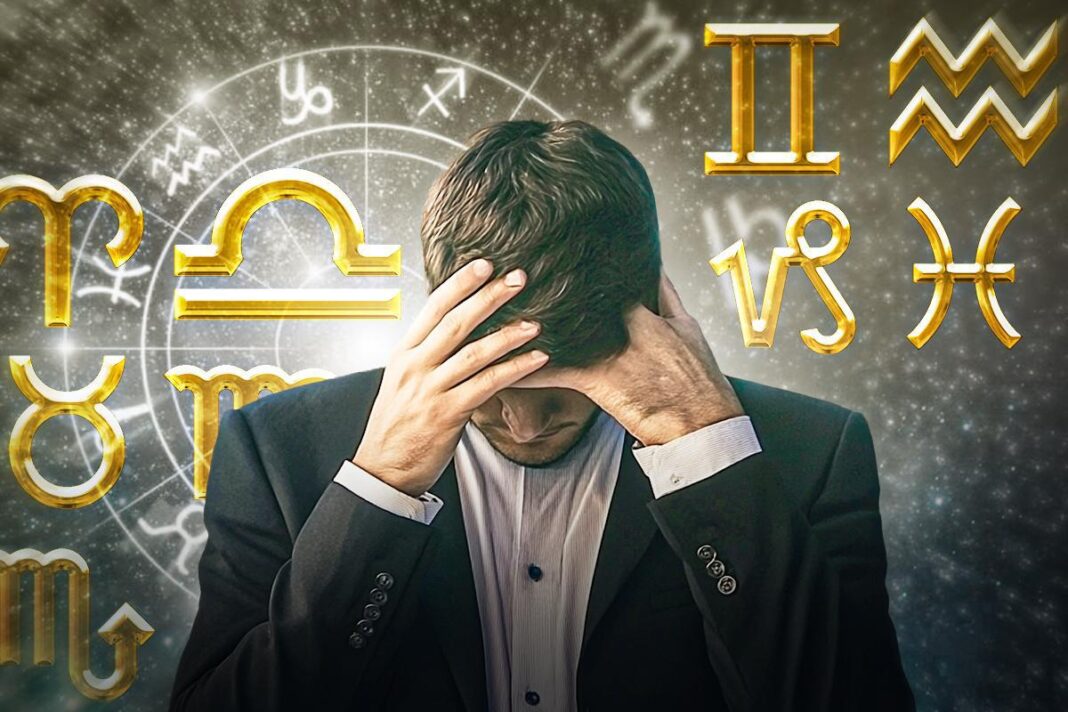 Susirūpinęs vyras laiko rankas prie galvos priešais Zodiako ženklų foną
