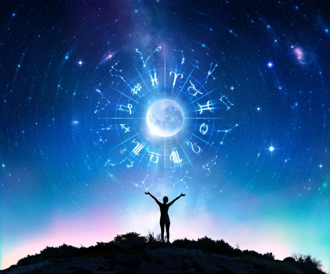 Žmogaus siluetas iškeltomis rankomis po žvaigždėtu dangumi su Zodiako ratu